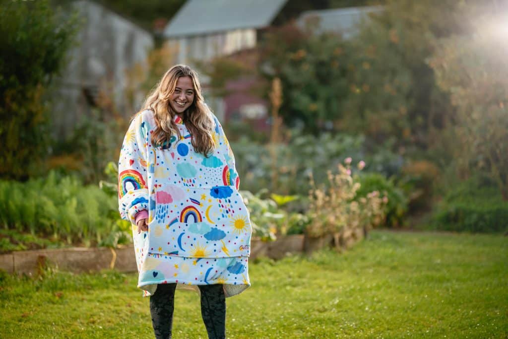 Girl wearing rainbow hoodei blanket in the garden